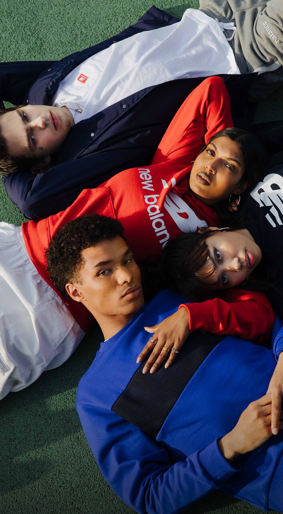 models wearing nb apparel and lying in the grass