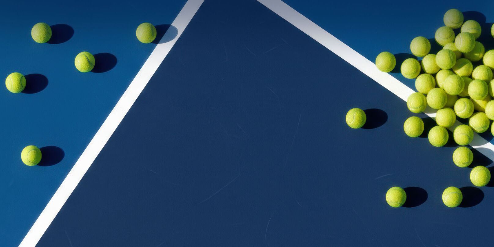 Tennis balls laying on a tennis court.