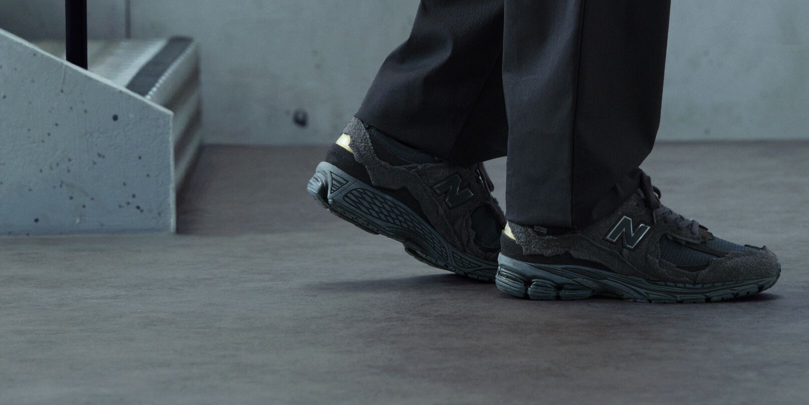 A pair of New Balance sneakers on concrete floor.