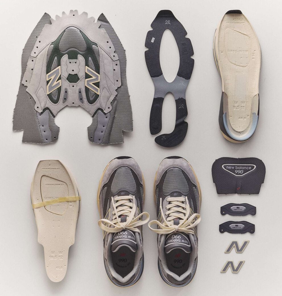 The 990v7 sneaker broken down into it's individual pieces laying on the ground.
