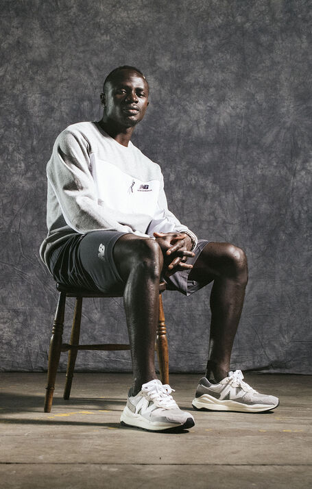 Sadio Mané sitting on chair in studio wearing grey NB apparel and shoes.
