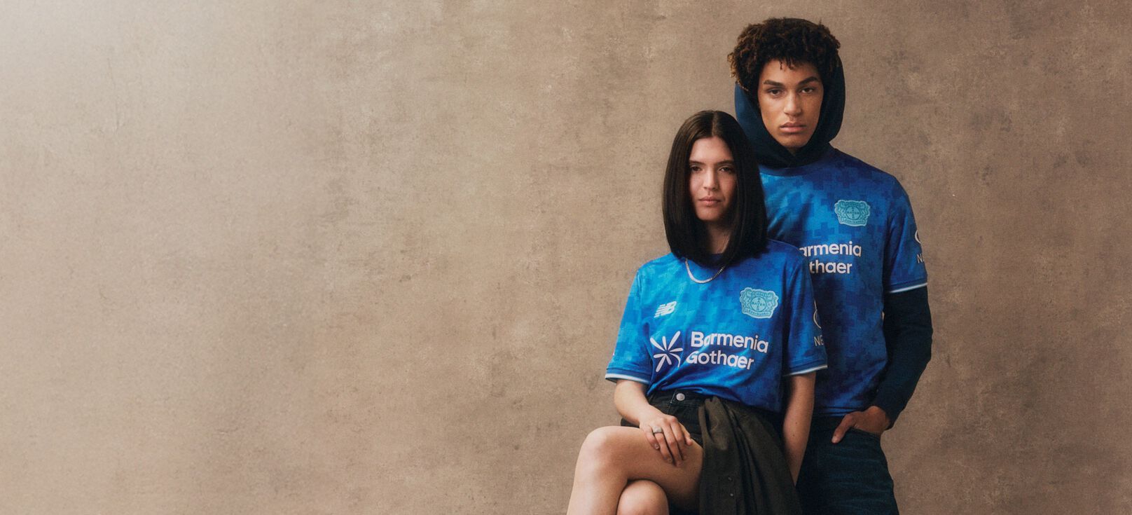 Young couple wearing blue soccer jerseys. 